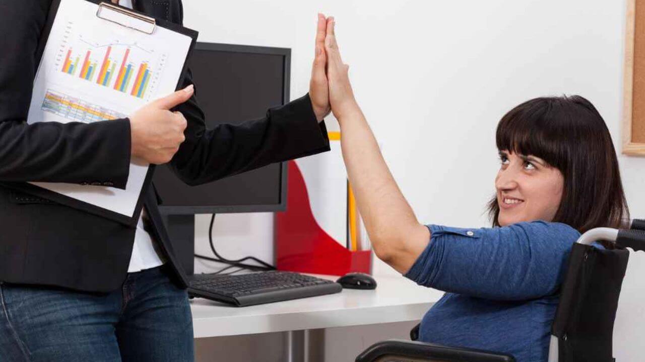 A Woman Giving a High Five to a Woman in Wheelchair