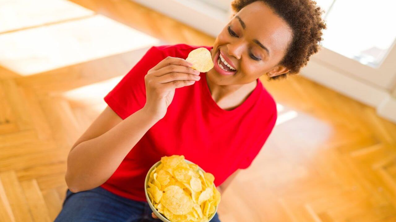 Beautiful, Curly-Haired Woman Eating Potatoe Chips