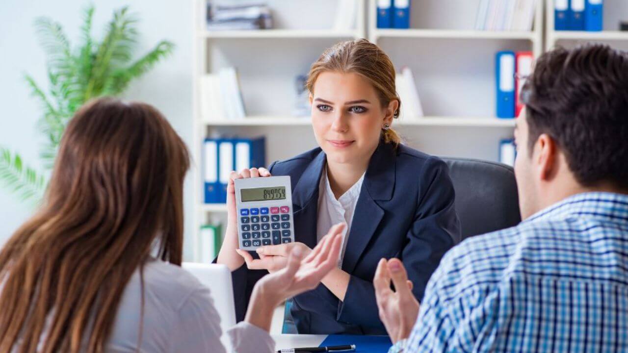 Beautiful Woman Showing to the Couple the Interest of Their Loan