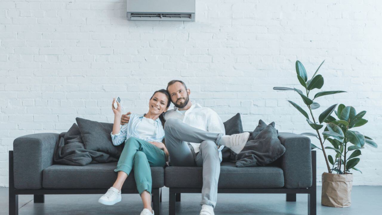 Couple Man and Woman Sitting on Couch in Living Room