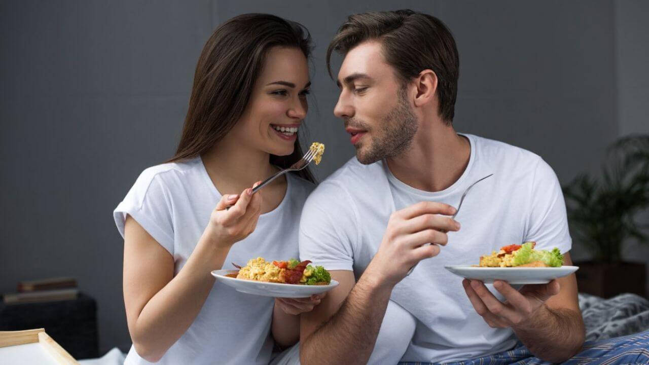 Couple Sweetly Having Eggs for Breakfast on Bed