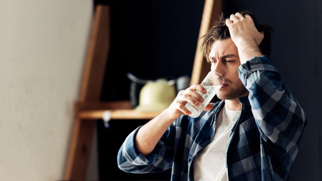 Drunk Man Holding Glass and Drinking Water After Party