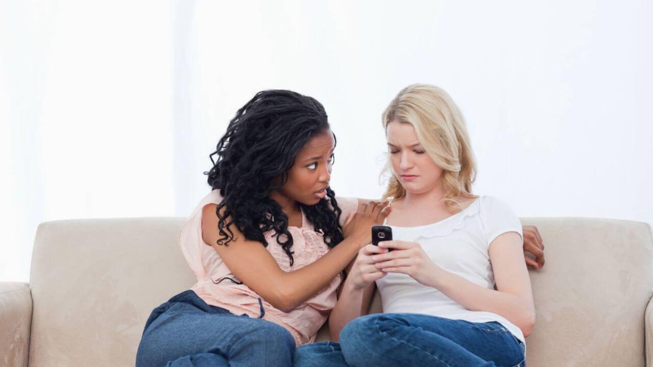 Sad Woman Sitting on Couch While Friend Comforts