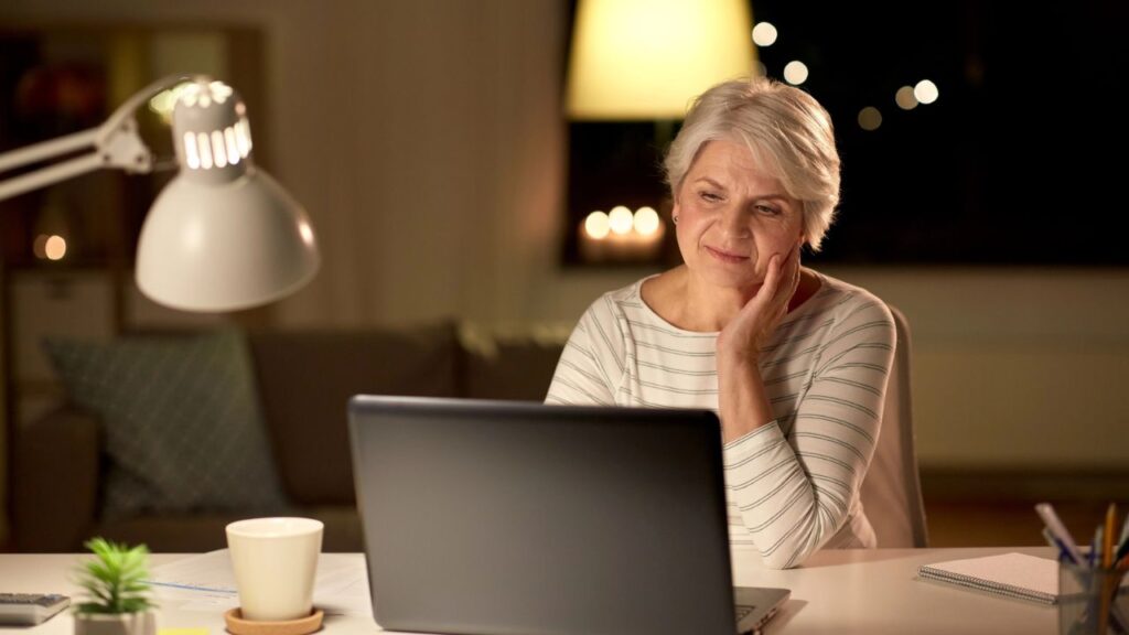 Senior Woman With Laptop At Home Looking Tired Stressed