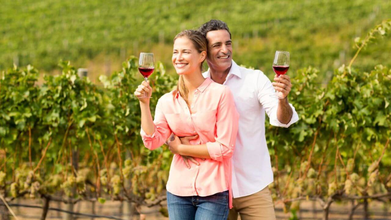 Sweet Couple Drinking Wine in a Vineyard