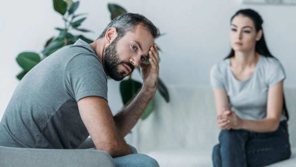 Upset Middle Aged Man Sitting On Couch With Girlfriend Argument Relationship Conflict