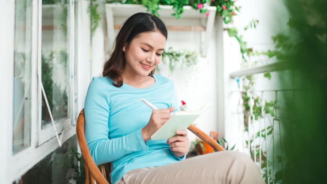 Woman Writing On A Diary Journal