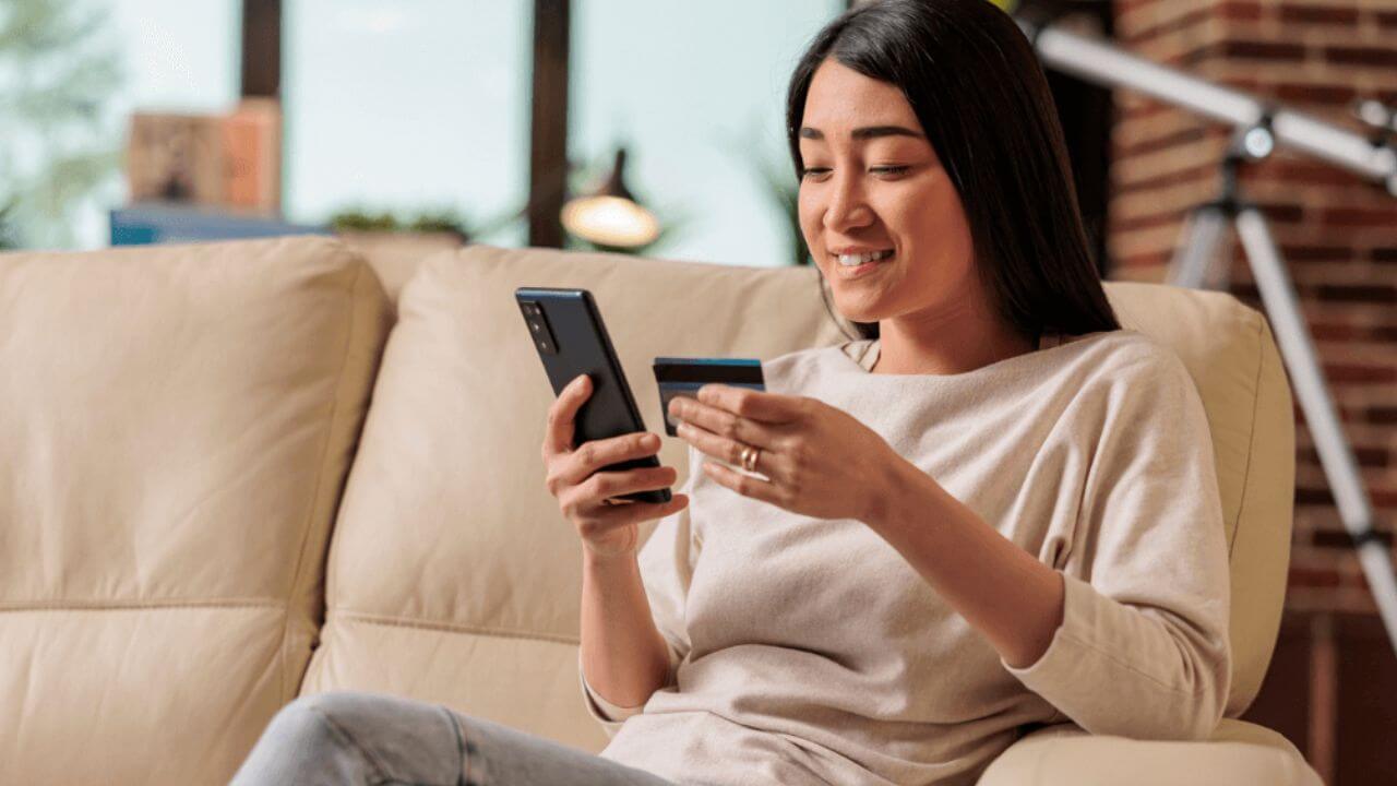 Woman buying online using credit card on phone