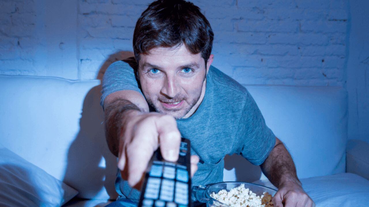 Young Man With a Remote Watching TV